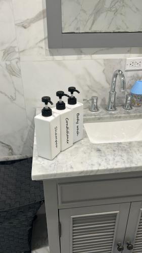 eine Badezimmertheke mit drei Zahnbürsten auf einem Waschbecken in der Unterkunft Ocean view in Nassau