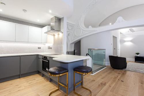a kitchen with a counter and two stools at Unique City Centre Luxury Three Bed Apartment in Manchester