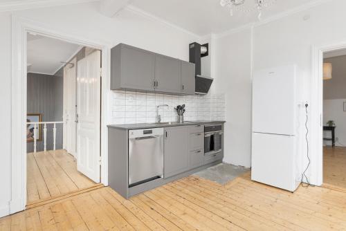 a white kitchen with a sink and a refrigerator at HernöRum Fiskekroken - Centralt och nära E4 in Härnösand