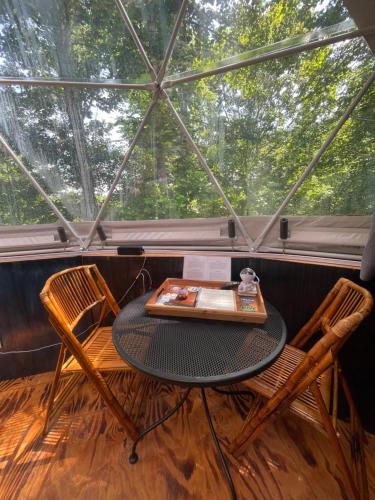 a table and chairs in a room with a large window at Humble Hippie in Rogers