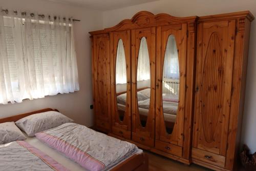 a bedroom with a large wooden cabinet next to a bed at Apartman-Vila-Sarajevo in Raskršće