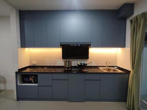 une cuisine avec des armoires bleues et un évier dans l'établissement Bristol park 233, à Ban Huai Yai