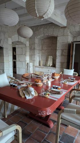 a red table with food on it in a room at Maison Nathis in Saint-Sulpice-de-Roumagnac