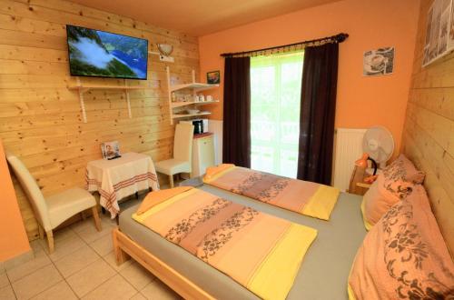 a bedroom with a bed and a tv on a wall at Árpi-Ria Üdülőház in Balatonfüred