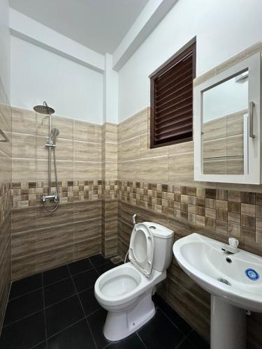 a bathroom with a toilet and a sink at Sun & Moon Hostel in Mirissa