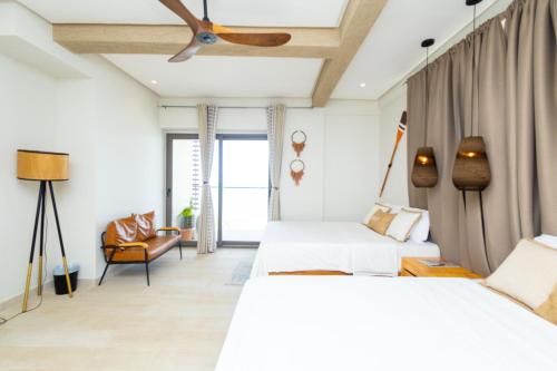 a bedroom with two beds and a ceiling fan at Serenity Terraces Beach, Resort in Kokrobite