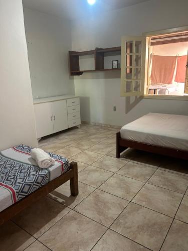 a bedroom with two beds and a window in it at Apto com garagem em Diamantina in Diamantina