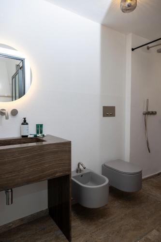 a bathroom with a sink and a toilet and a mirror at Masseria LOGGIA PUCCI in Torre Chianca
