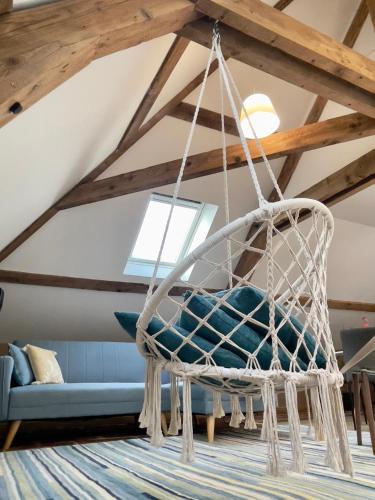 a hanging hammock in a living room with a couch at Appartements de Diane - JOIGNY in Joigny