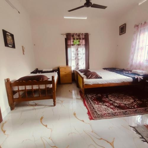 a bedroom with two beds and a window at Ebenezer Stay in Trivandrum