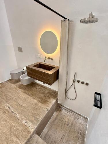 a bathroom with a sink and a toilet and a mirror at Masseria LOGGIA PUCCI in Torre Chianca