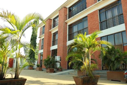 Un edificio con palmeras delante. en Jasmine Hotel Soroti, en Soroti