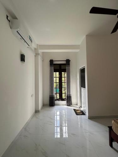 an empty room with white walls and a large window at Sun & Moon Hostel in Mirissa