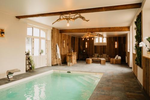 a swimming pool in a house with a living room at le petit château de Célestine in Segonzac