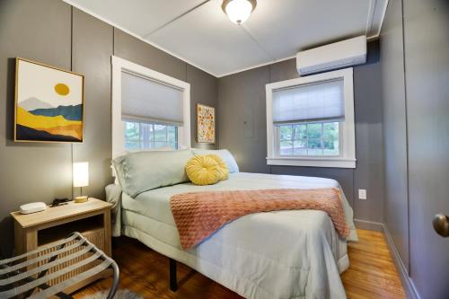 ein Schlafzimmer mit einem Bett mit einem gelben Kissen darauf in der Unterkunft Lakeside Haven, a Modern Cottage with Lake Views in Effort