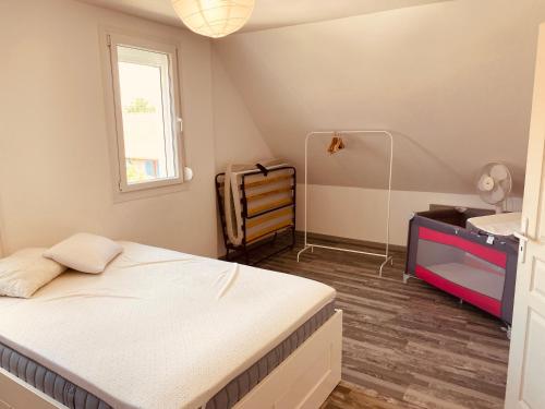 a bedroom with a bed and a desk and a window at Le Suroit Etaples in Étaples