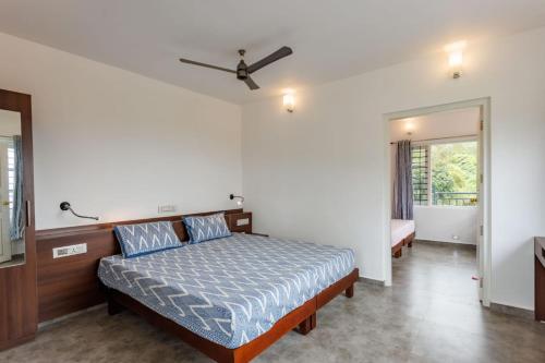 a bedroom with a bed and a ceiling fan at Royal Mist Villa in Munnar