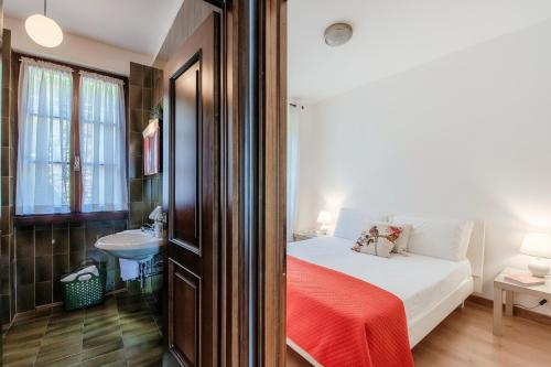 a bedroom with a bed with a red blanket on it at Musso Waterside - by MyHomeInComo in Musso