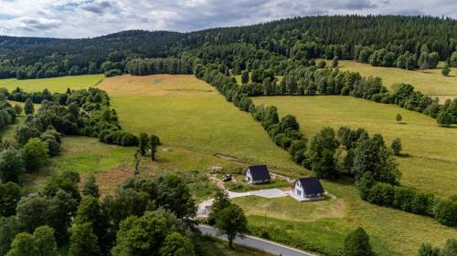 an aerial view of a farm with a house and a road at Osada Niebieskich Drzwi in Stronie Śląskie