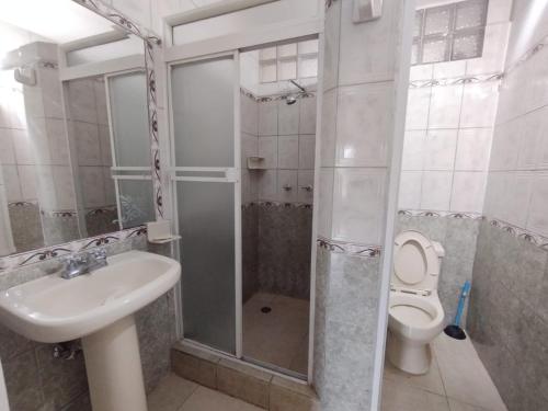 une salle de bain avec douche, lavabo et toilettes dans l'établissement Dpto PUNTA ARENA ATACAMES, à Atacames