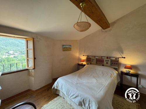 a bedroom with a bed and a window at Ca la rigalla in Amélie-les-Bains-Palalda