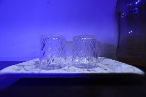 two glass vases sitting on a white plate at The Bed And Rock Kalkaji in New Delhi