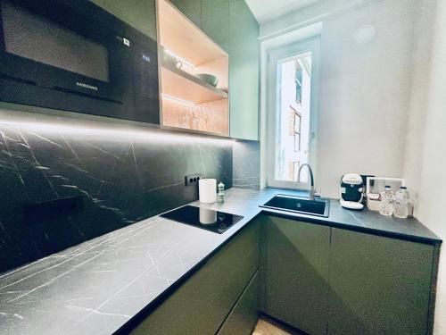 a kitchen with green cabinets and a sink at Historic Business Loft in Iaşi