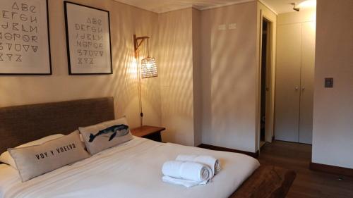 a bedroom with a bed with towels on it at HOM I Depto Familiar con parking incluido in Puerto Varas
