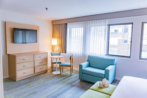 a hotel room with a bed and a chair and a tv at The Inn at Longwood Medical in Boston