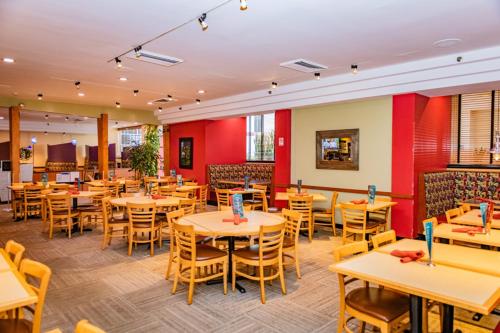 un restaurant avec des tables, des chaises et des murs rouges dans l'établissement The Inn at Longwood Medical, à Boston