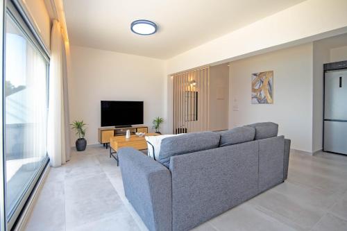 a living room with a couch and a table at Blue Sea Benitses - Beachfront Apartment in Benitses