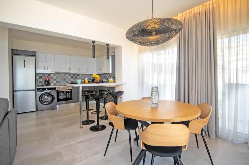 a kitchen and dining room with a wooden table and chairs at Blue Sea Benitses - Beachfront Apartment in Benitses