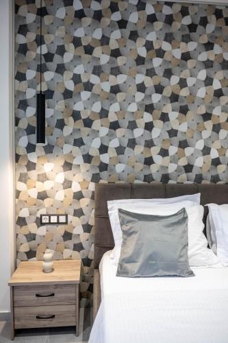 a bedroom with a bed and a wooden nightstand next to a wall at Blue Sea Benitses - Beachfront Apartment in Benitses