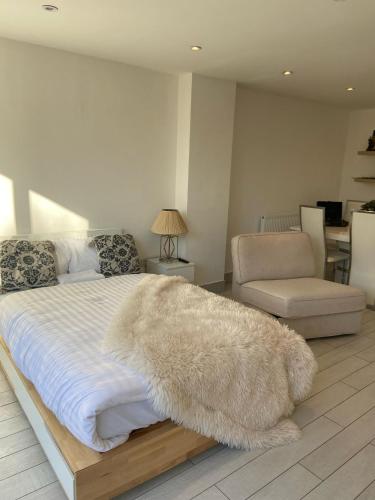 a bedroom with a white bed with a rug on it at Blue House in Stone Grove