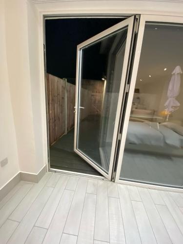 a sliding glass door in a room with a bedroom at Blue House in Stone Grove