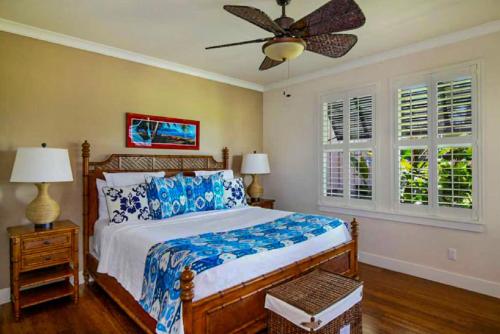 una camera da letto con un letto e un ventilatore a soffitto di Stunning Poipu Townhomes for 12 with AC - Spacious 6 Bedrooms a Koloa