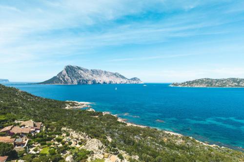 a view of the ocean with mountains in the distance at Villa Caterina in Monte Petrosu