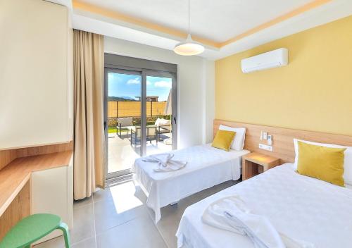 a hotel room with two beds and a balcony at Villa Serenity in Kas