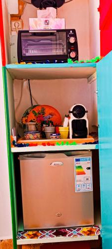 a refrigerator with a toaster oven on top of it at Riad SULTANA lateral seaview in Saidia 