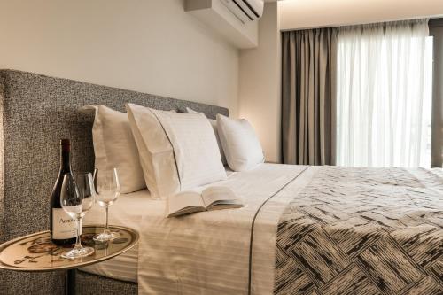 a bedroom with a bed with a table with wine glasses at Ostria Village in Syvota