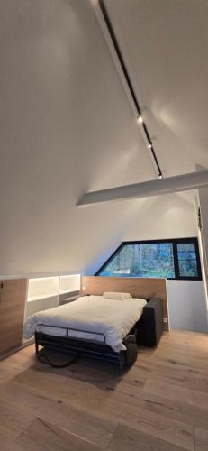 a bedroom with a bed in a room with a window at Guesthouse Les Buttes in Bruges