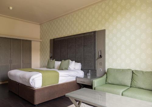 a hotel room with a bed and a couch at Vale Resort in Hensol