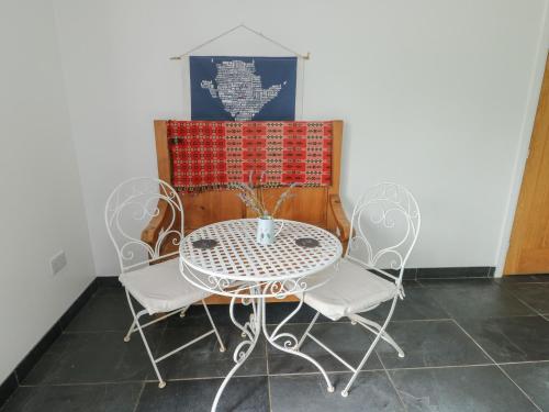 a table and two chairs and a table and a box at Seiriol Shepherds hut in Llanfaelog