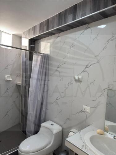 a bathroom with a toilet and a shower and a sink at Las Palmas Apart in Tacna