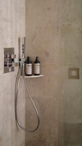 a shower with two bottles on a shelf in a bathroom at Five Seas Cannes, a Member of Design Hotels™ in Cannes