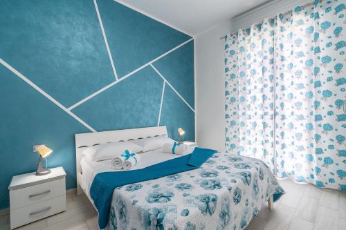 a bedroom with a bed and a blue wall at Le Quattro Perle Apartments in Pachino