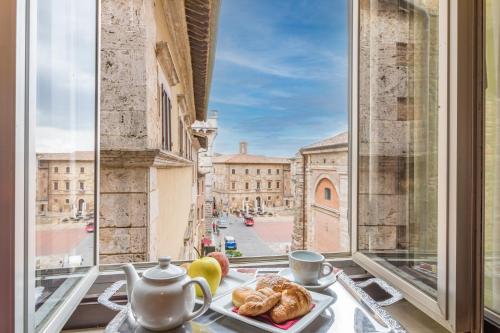 an open window with a plate of food on a table at Bellarmino Boutique Apartments, Montepulciano in Montepulciano