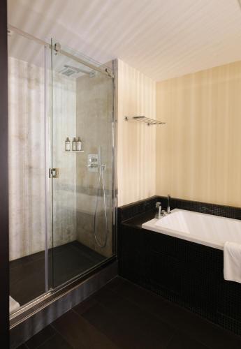 a bathroom with a shower and a tub and a sink at Five Seas Cannes, a Member of Design Hotels™ in Cannes