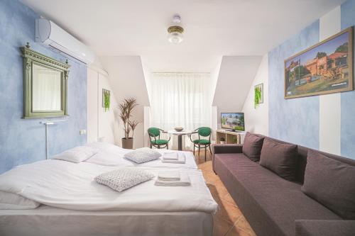 a bedroom with a large bed and a couch at Charlie Vendégház in Sé