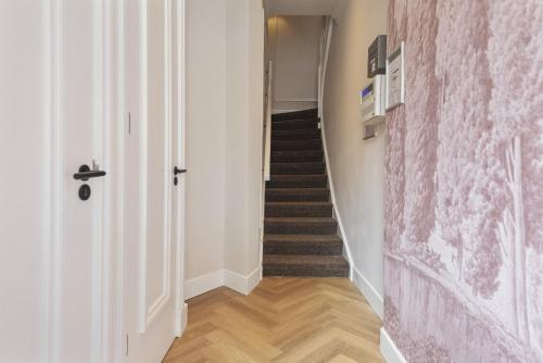 a hallway with a staircase with a pink wall at Boutique hotel Novi in Zandvoort